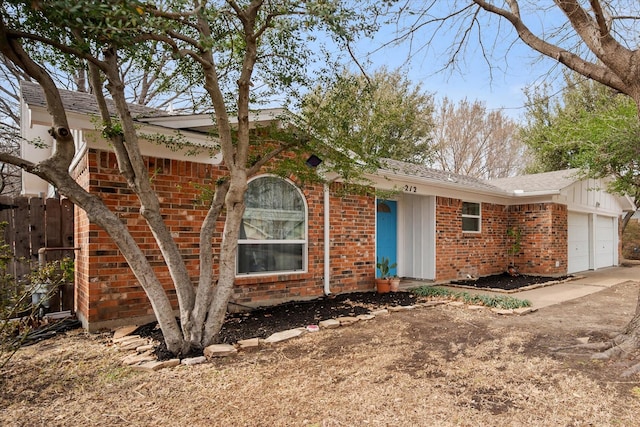 ranch-style home with board and batten siding, brick siding, and an attached garage