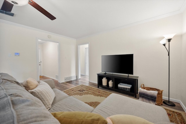 living room featuring baseboards, visible vents, ceiling fan, wood finished floors, and crown molding