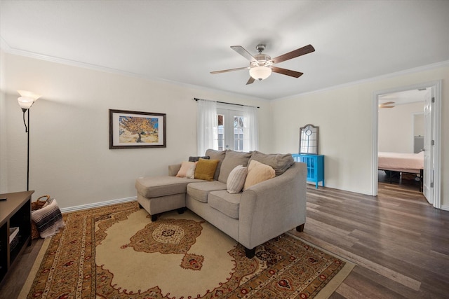 living room featuring ornamental molding, baseboards, and wood finished floors