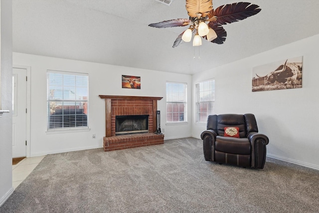 sitting room with carpet, a brick fireplace, a ceiling fan, and baseboards