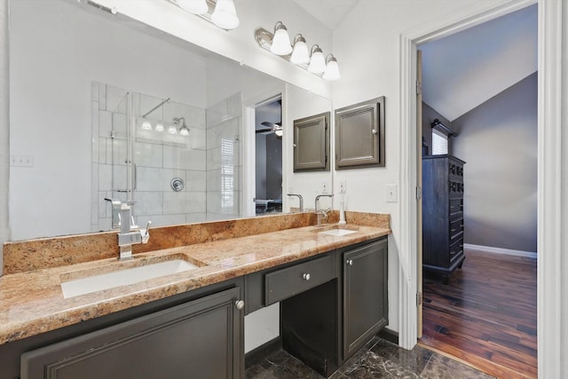 full bath with double vanity, a shower stall, ceiling fan, and a sink