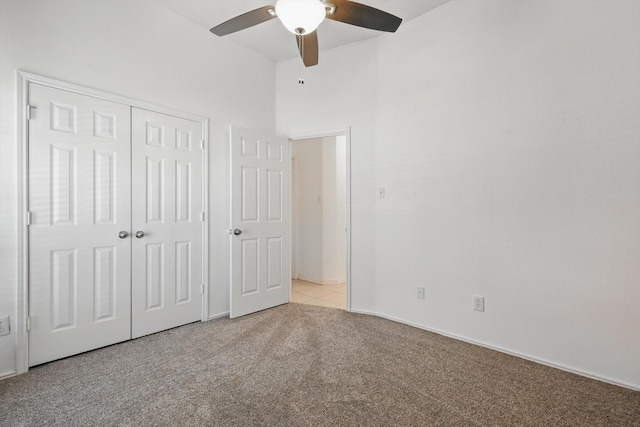 unfurnished bedroom with a ceiling fan, a closet, and light carpet