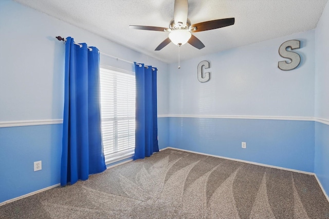 carpeted empty room featuring a textured ceiling and ceiling fan