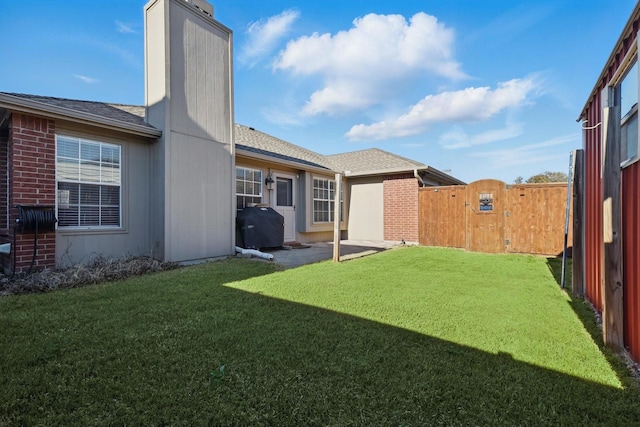 view of yard with a patio, fence, and a gate