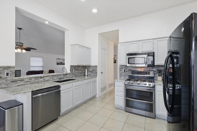 kitchen with ceiling fan, a sink, stainless steel appliances, backsplash, and light tile patterned flooring