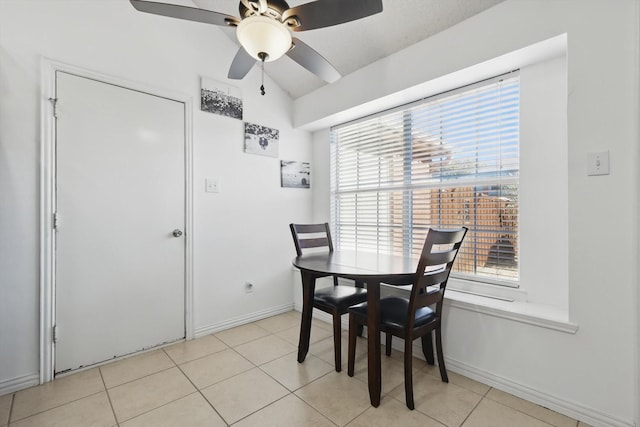 dining area featuring light tile patterned floors, vaulted ceiling, a ceiling fan, and baseboards