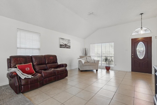 living room featuring vaulted ceiling, baseboards, and light tile patterned floors