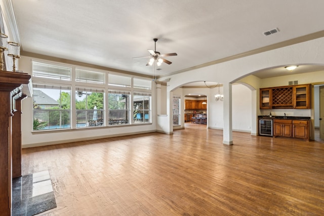 5805 Parker Village Dr, Parker, TX 75002 - unfurnished living room with beverage cooler, ceiling fan, arched walkways, wet bar, and wood finished floors