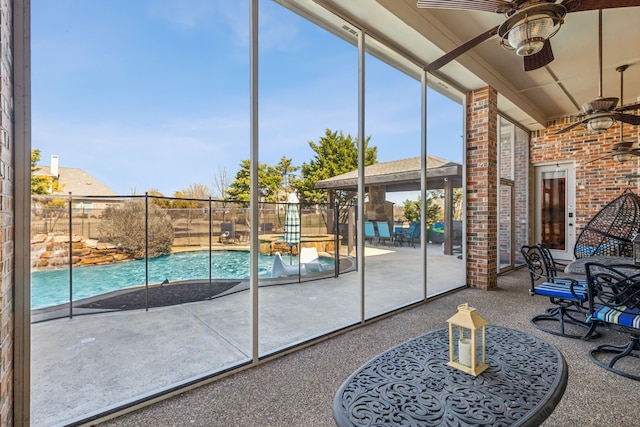 unfurnished sunroom with ceiling fan