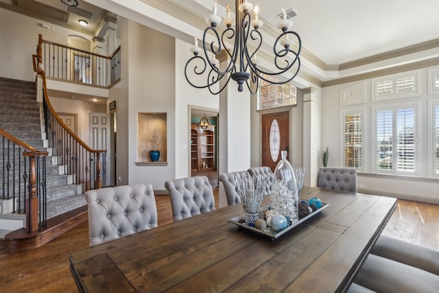 dining area with stairs, ornamental molding, wood finished floors, and a wealth of natural light