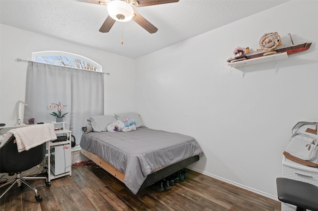 bedroom featuring a ceiling fan, a textured ceiling, baseboards, and wood finished floors