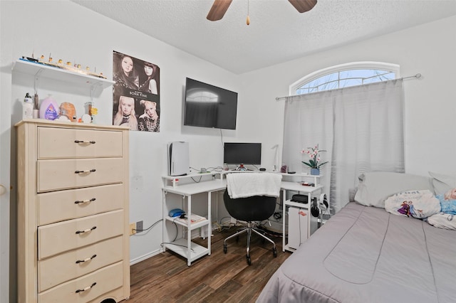 bedroom with dark wood-type flooring, ceiling fan, and a textured ceiling