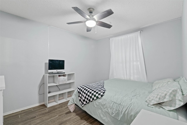 bedroom with a textured ceiling, wood finished floors, and a ceiling fan