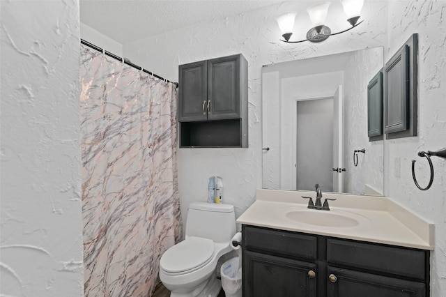 full bathroom with toilet, vanity, a textured ceiling, and a textured wall