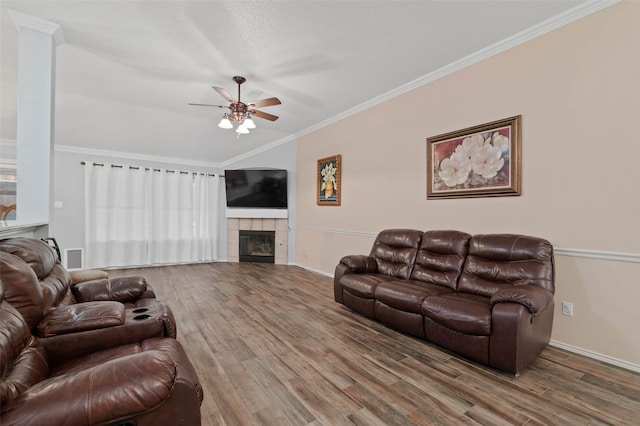 living area with ceiling fan, a tile fireplace, wood finished floors, and crown molding