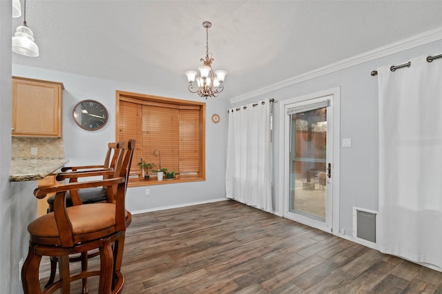 dining space with dark wood-style floors, baseboards, ornamental molding, and a chandelier