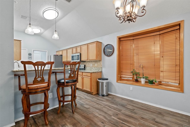 kitchen with lofted ceiling, visible vents, decorative backsplash, appliances with stainless steel finishes, and dark wood-type flooring