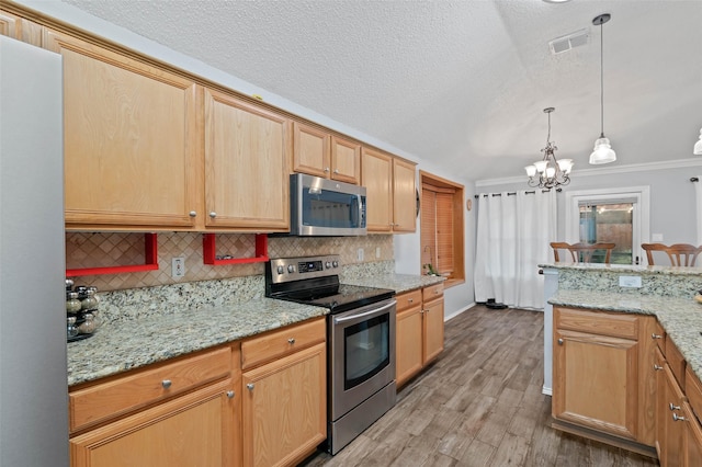 kitchen with appliances with stainless steel finishes, visible vents, light wood-style flooring, and decorative backsplash