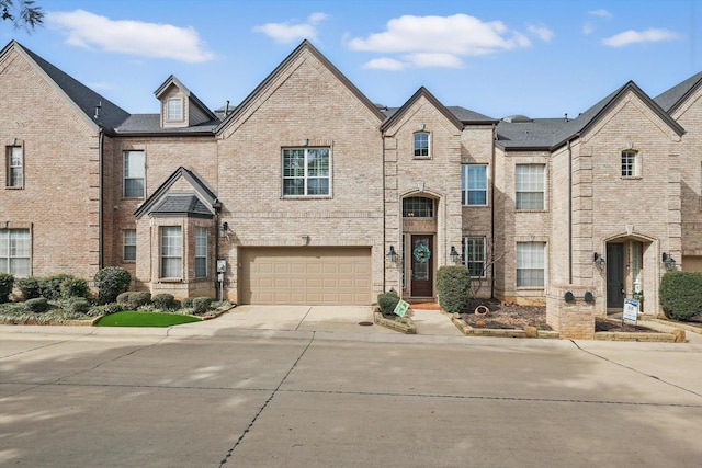 view of front of property featuring a garage, brick siding, and driveway