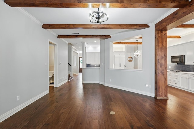 unfurnished living room with dark wood-type flooring, beamed ceiling, an inviting chandelier, and baseboards