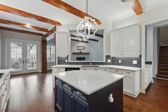 kitchen featuring a chandelier, white cabinets, a sink, and decorative backsplash