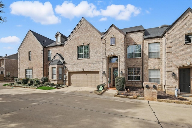 view of front of house featuring concrete driveway, brick siding, and an attached garage