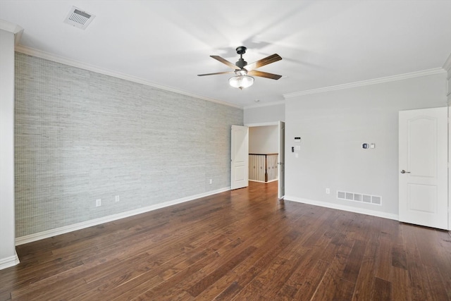 empty room featuring ornamental molding, visible vents, baseboards, and wood finished floors