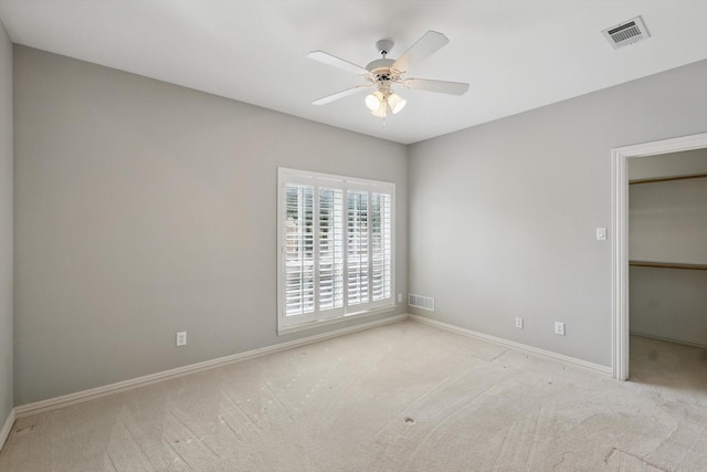 unfurnished bedroom featuring carpet floors, baseboards, a spacious closet, and visible vents