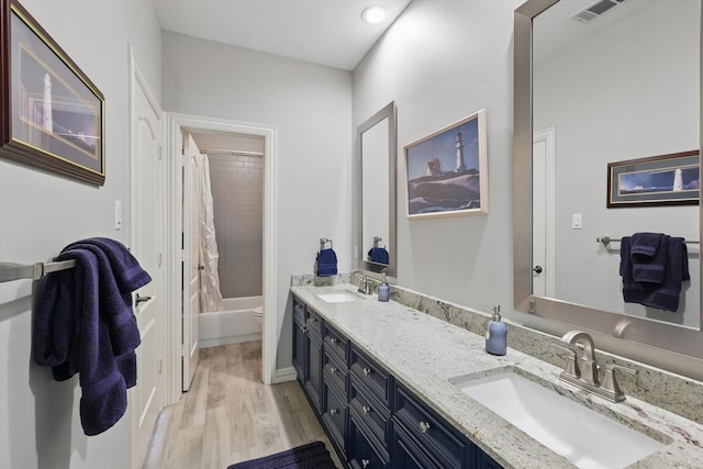 bathroom with toilet, visible vents, a sink, and wood finished floors