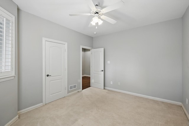 unfurnished bedroom with a ceiling fan, carpet flooring, visible vents, and baseboards