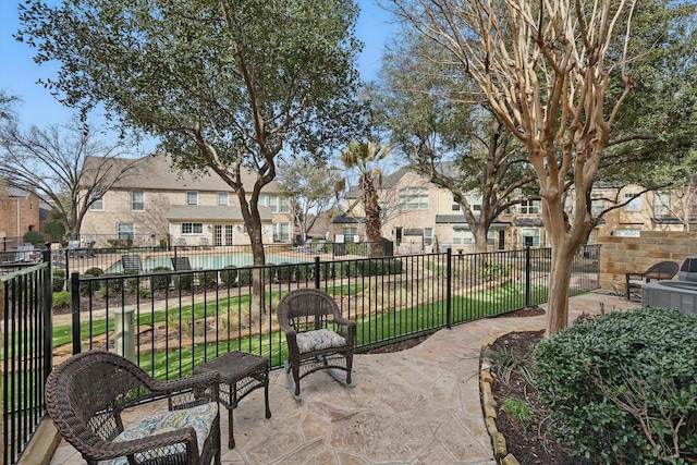 view of patio / terrace with a residential view, fence, and a community pool