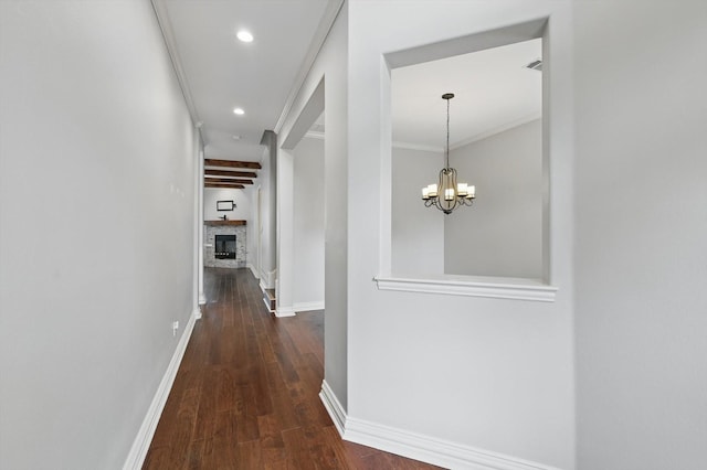 hall with a notable chandelier, recessed lighting, dark wood-type flooring, ornamental molding, and baseboards