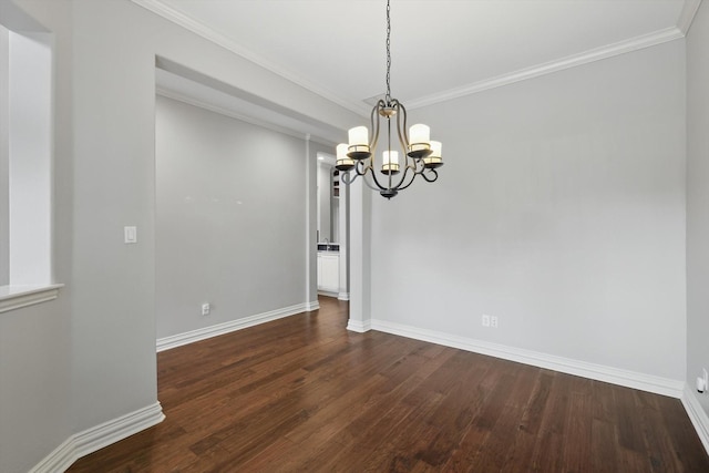 unfurnished dining area with a chandelier, ornamental molding, dark wood finished floors, and baseboards