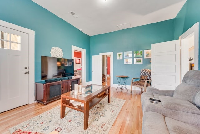 living area with visible vents, baseboards, and wood finished floors