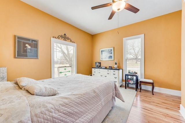 bedroom with ceiling fan, baseboards, and light wood-style floors