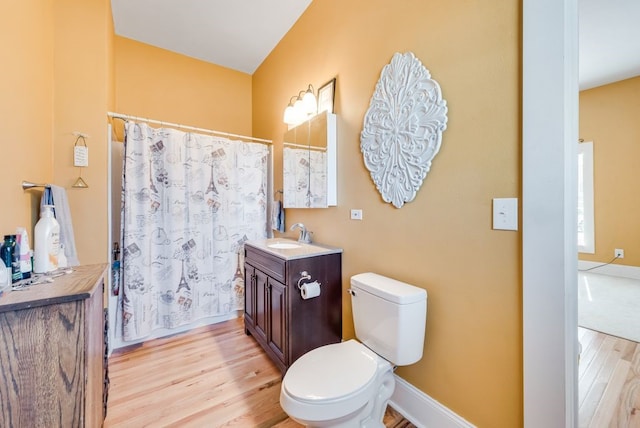 full bathroom with vanity, a shower with shower curtain, wood finished floors, baseboards, and toilet