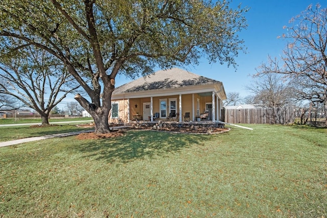 bungalow with covered porch, a front lawn, and fence