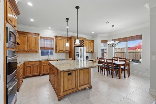 kitchen featuring tasteful backsplash, a center island, brown cabinets, stainless steel appliances, and a sink