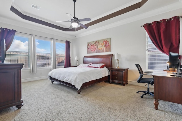 bedroom featuring visible vents, baseboards, a tray ceiling, crown molding, and light colored carpet