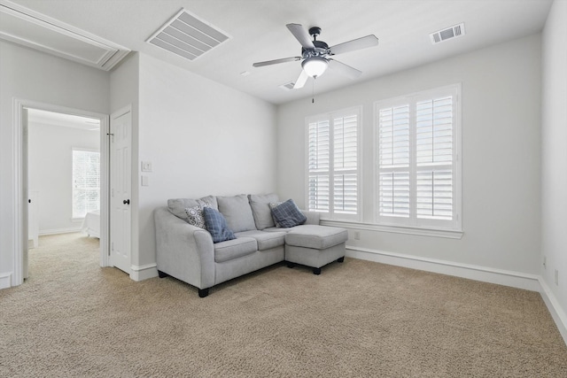 carpeted living room featuring visible vents, plenty of natural light, and a ceiling fan