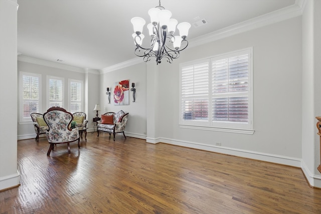 living area featuring visible vents, crown molding, baseboards, an inviting chandelier, and wood finished floors