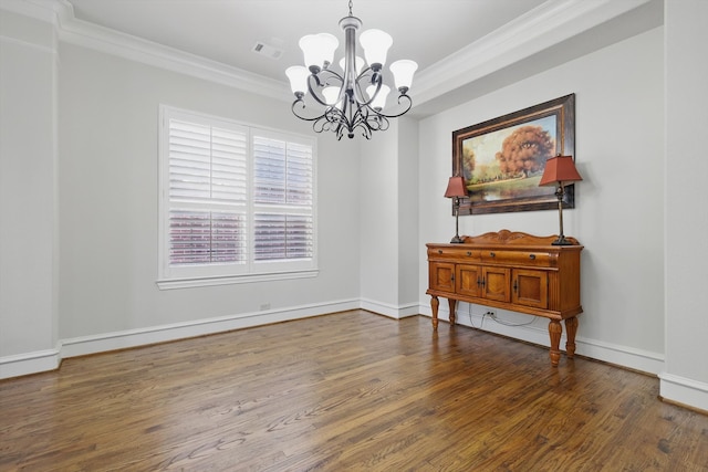 dining area featuring dark wood-type flooring, baseboards, a chandelier, and ornamental molding