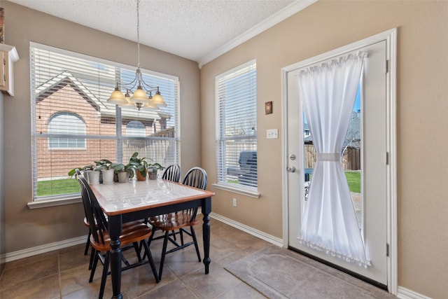 dining space with a notable chandelier, baseboards, a textured ceiling, and tile patterned floors