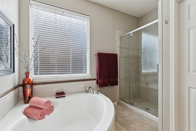 full bathroom with a healthy amount of sunlight, a garden tub, and a shower stall