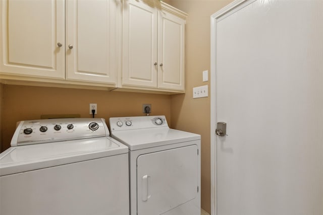 washroom with cabinet space and washing machine and clothes dryer