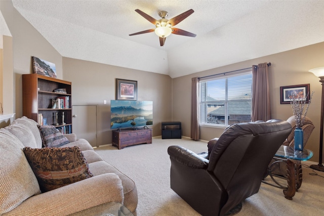 living area with carpet, vaulted ceiling, a textured ceiling, ceiling fan, and baseboards