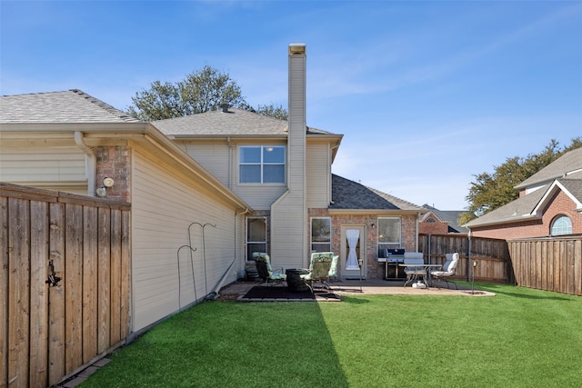 back of house featuring a patio area, a chimney, fence, and a yard