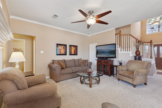 living area with carpet floors, visible vents, stairway, and crown molding