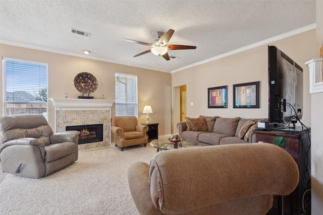 living area featuring a wealth of natural light, a fireplace, visible vents, and light colored carpet