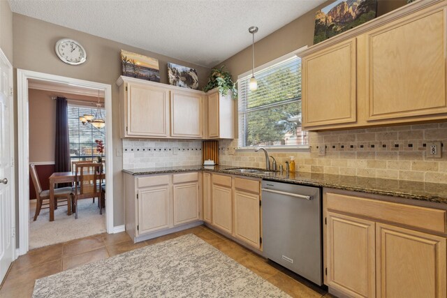 kitchen featuring plenty of natural light, light brown cabinets, dishwasher, and a sink